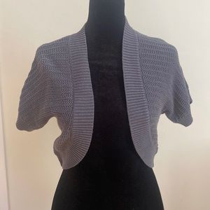 Super cute mini sweater. Just covers top and shoulders. Very versatile! A must!